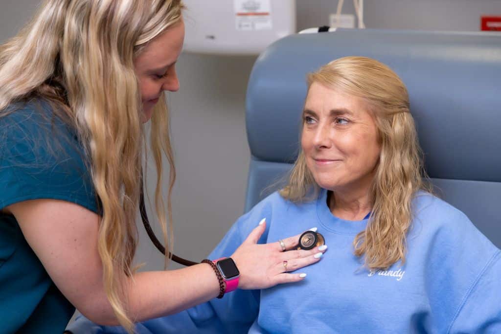 Clinician using a stethoscope for a cardiac exam at Gadsden Cancer Clinic